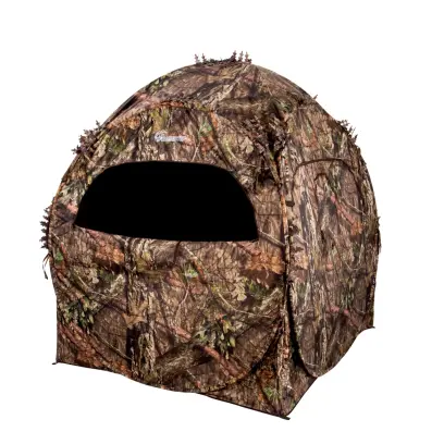DOGHOUSE HUNTING BLIND Ameristep DOGHOUSE GROUND BLIND per 2 persone in Mossy Oak Break-Up Country. La copertura 3D si nasconde agli occhi della selvaggina. Borsa per il trasporto, picchetti e legacci. Ingombro: 60 "x60", altezza: 66".