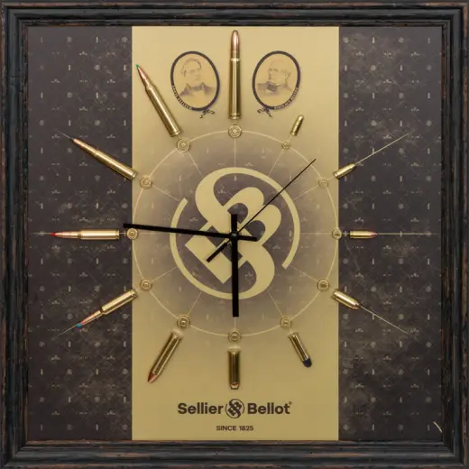 Zegar ścienny Modern Sellier & Bellot Nowoczesny zegar Sellier & Bellot w drewnianej ramie z prawdziwymi nabojami jako znacznikami godzin. Stylowa dekoracja i unikalny gadżet kolekcjonerski dla fanów S&B, strzelców i myśliwych.